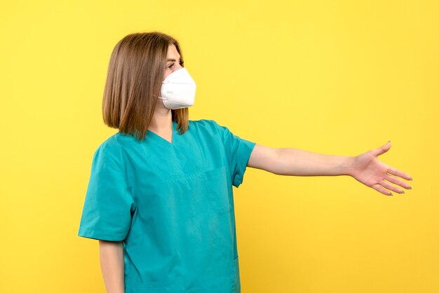 Front view female doctor shaking hands on yellow space