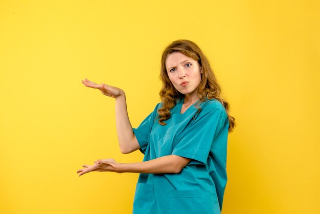 Front view of female doctor showing size on yellow wall