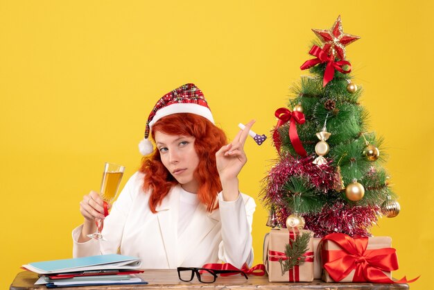 Free photo front view female doctor sitting and celebrating christmas with champagne