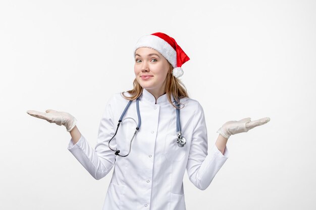 Front view of female doctor smiling on white wall