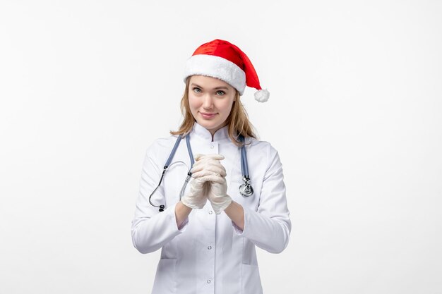 Front view of female doctor smiling on white wall