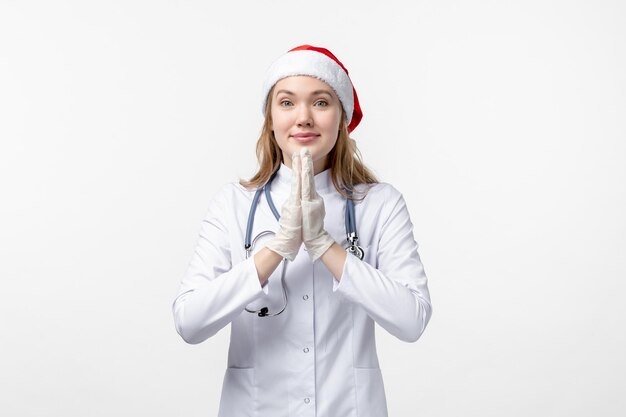 Front view of female doctor smiling on white wall