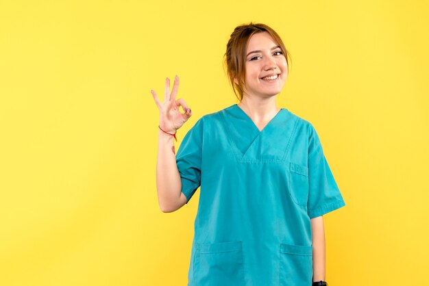 Front view female doctor smiling on a yellow space