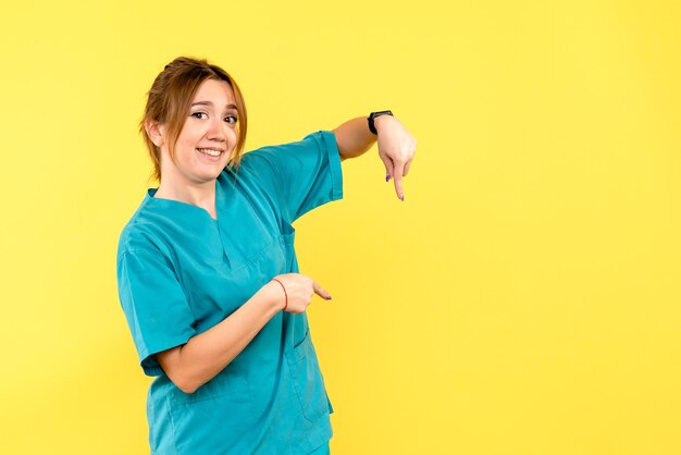 Front view female doctor smiling on a yellow space