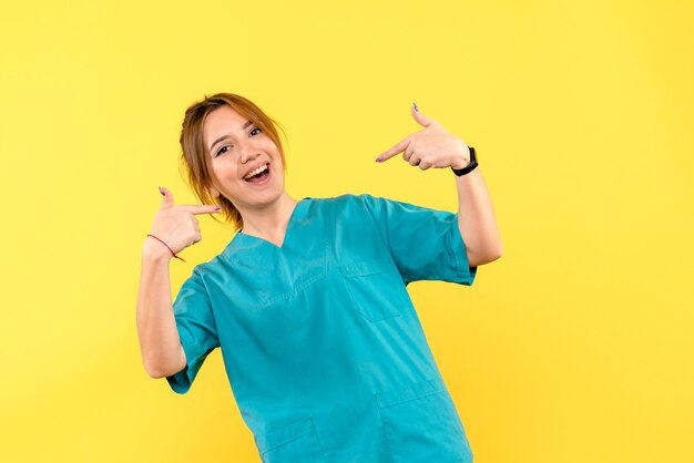 Front view female doctor smiling on yellow space