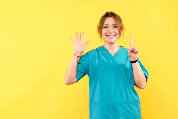 Front view female doctor smiling on yellow space