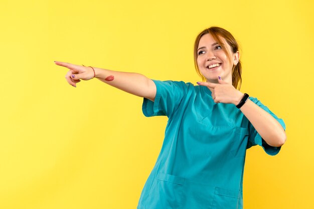 Front view female doctor smiling on yellow space