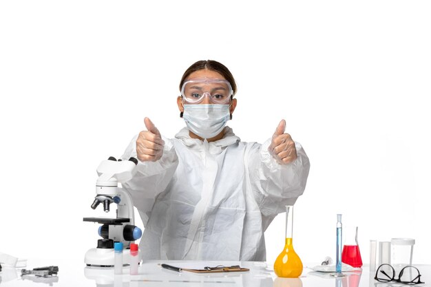 Front view female doctor in special suit and wearing mask posing on white background covid- pandemic coronavirus virus health