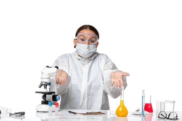 Front view female doctor in special suit and wearing mask on white background covid- virus pandemic coronavirus