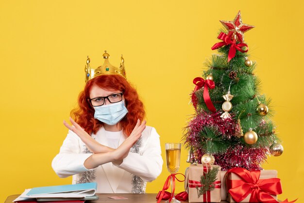 Front view female doctor in sterile mask around xmas presents