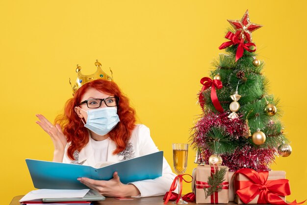 Front view female doctor in sterile mask checking documents