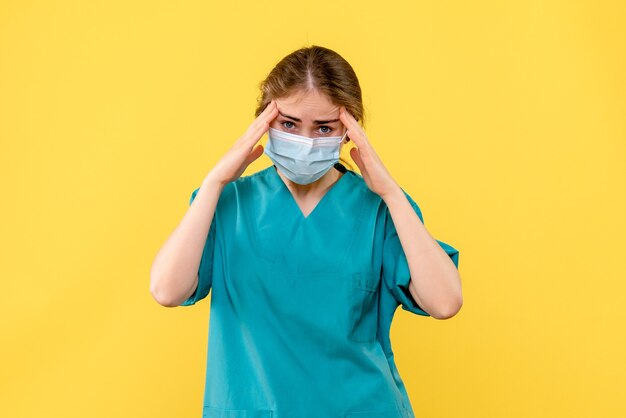 Front view female doctor stressed on yellow background covid- hospital health pandemic