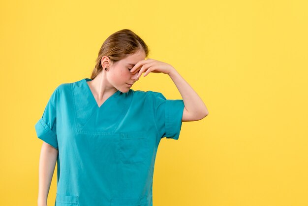 Front view female doctor stressed on yellow background medic health hospital virus emotion