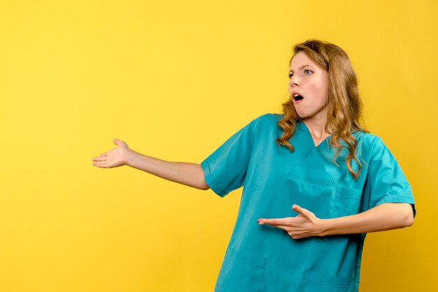 黄色の壁で話している女性医師の正面図
