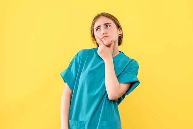 Вид спереди женщина-врач думает на желтом фоне больница эмоции медик здоровье