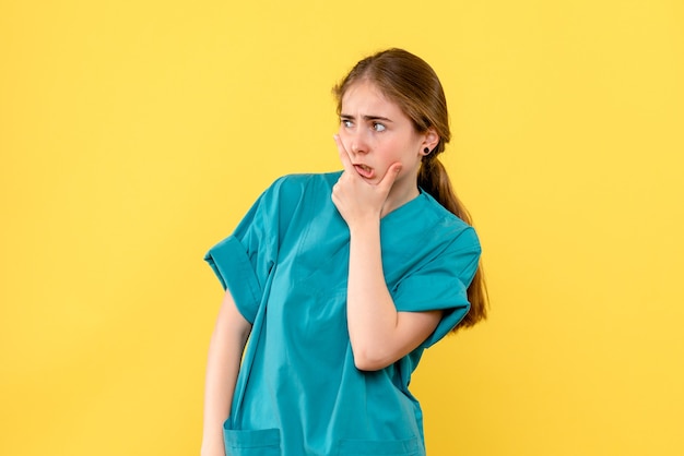 Вид спереди женщина-врач думает на желтом фоне вирус больницы здоровья медика