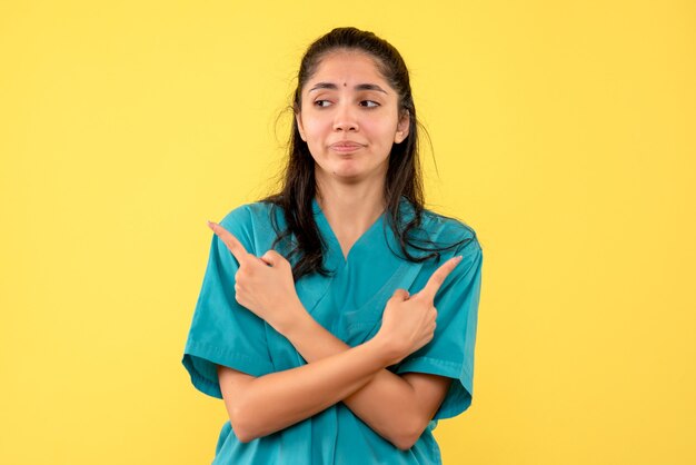 Front view female doctor in uniform crossing hands standing