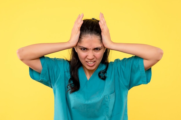 Free photo front view female doctor in uniform holding her head