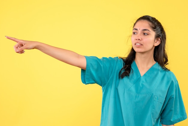 立っている何かを指している制服を着た女性医師の正面図