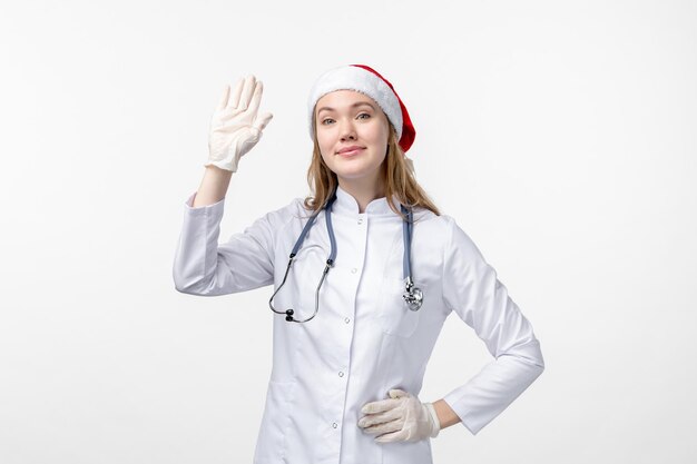 白い壁に手を振っている女性医師の正面図