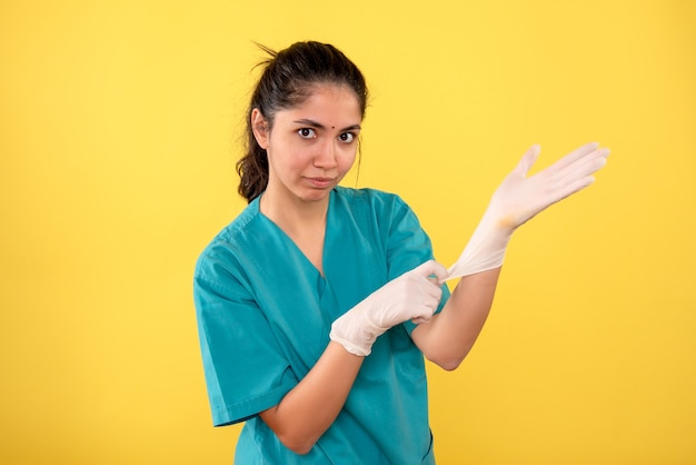 Front view female doctor wearing latex gloves standing