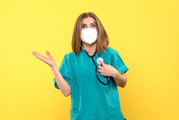 Front view female doctor wearing sterile mask on yellow space