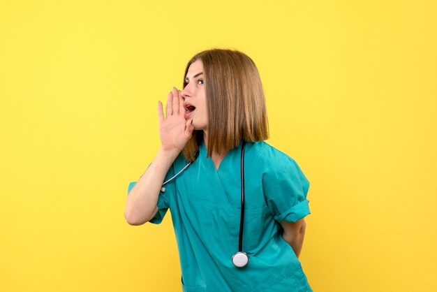 Front view female doctor whispering on yellow space