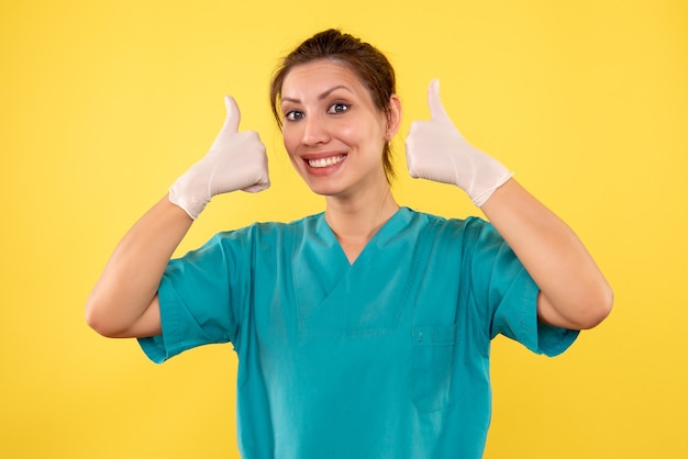 Вид спереди женщина-врач в белых перчатках на желтом фоне