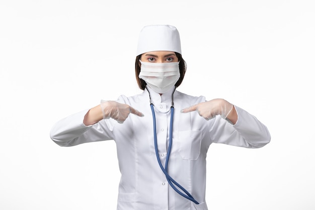 흰색 책상 질병 질병 유행성 바이러스 covid-에 코로나 바이러스로 인해 마스크가있는 흰색 의료 소송에서 전면보기 여성 의사