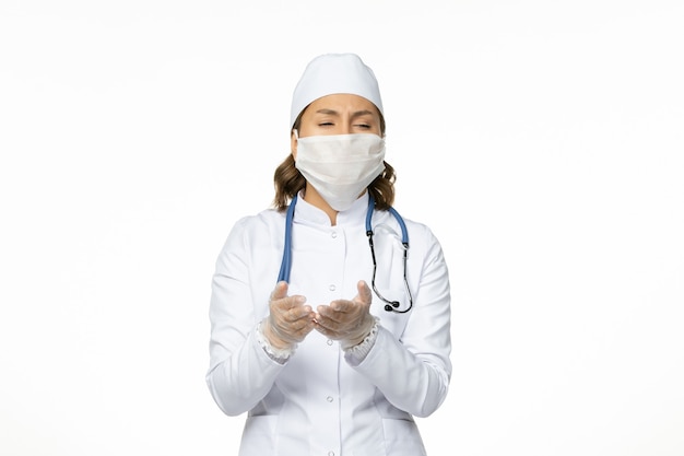 白い医療スーツを着た正面図の女性医師と白い床のウイルス病パンデミックコビッドのコロナウイルスによるマスク