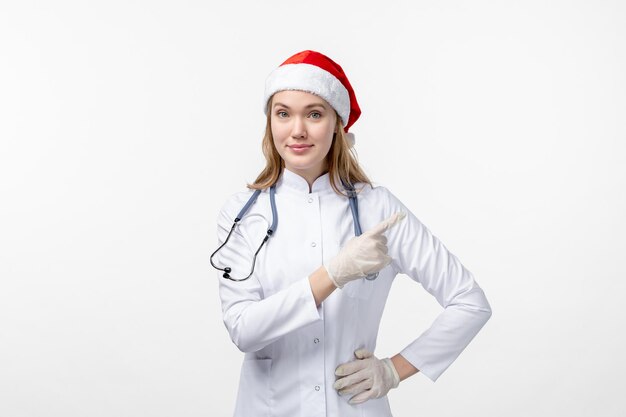 Front view of female doctor on white wall