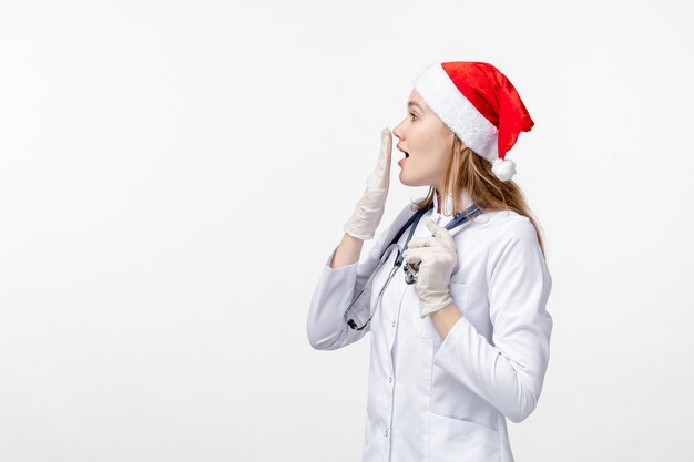 Front view of female doctor on white wall