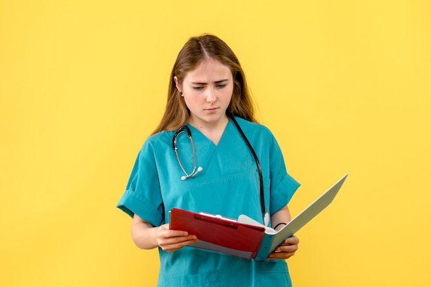 Front view female doctor with analyzes on yellow background nurse hospital health virus