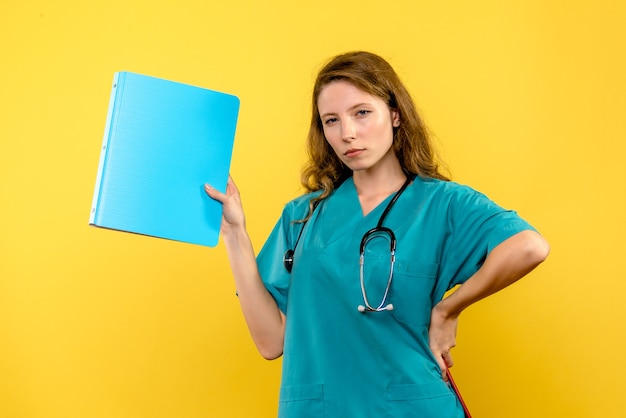 Front view female doctor with analyzes on a yellow space