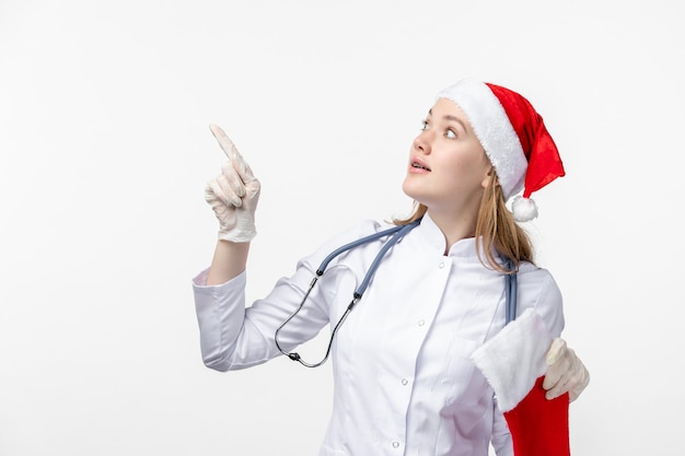 Front view of female doctor with big holiday sock on white wall