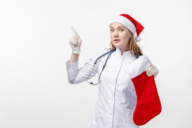 Front view of female doctor with big holiday sock on white wall