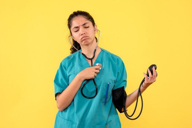 Front view female doctor with closed eyes holding sphygmomanometers standing