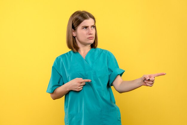 Front view female doctor with confused expression on yellow space