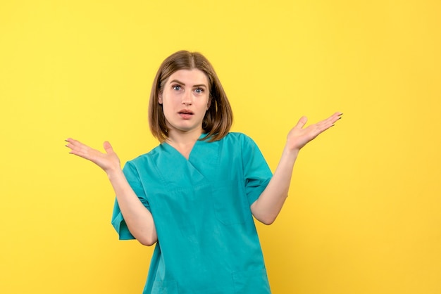 Front view female doctor with confused expression on yellow space