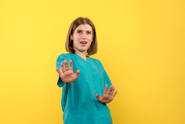 Front view female doctor with displeased expression on yellow space