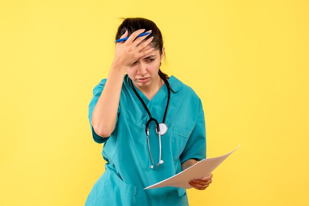 Free photo front view female doctor with documents holding her head