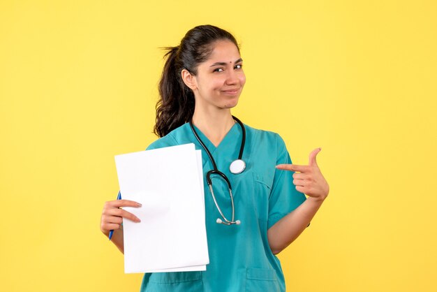 Front view female doctor with documents pointing at herself