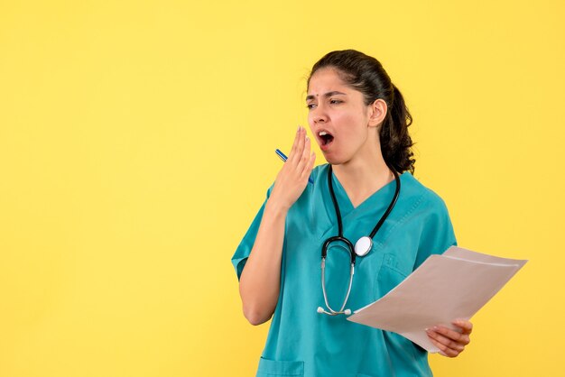 Front view female doctor with documents yawning