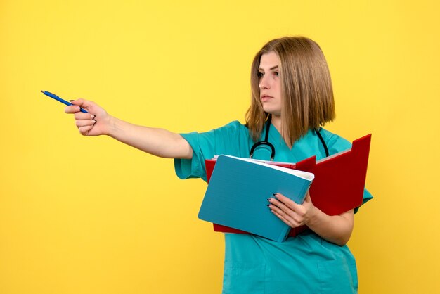 Front view female doctor with documents on yellow space