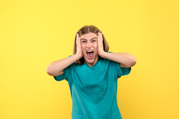 Front view female doctor with emotional face on a yellow space