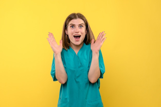 Front view female doctor with excited expression on a yellow space