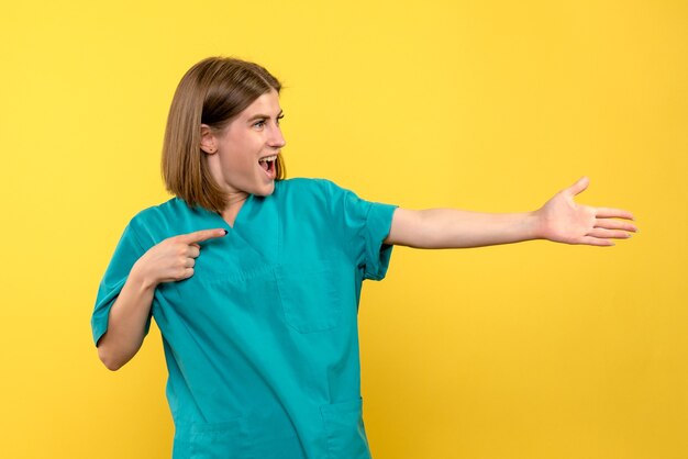 Front view female doctor with excited expression on a yellow space