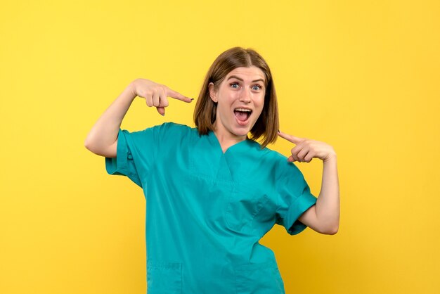 Front view female doctor with excited expression on yellow space