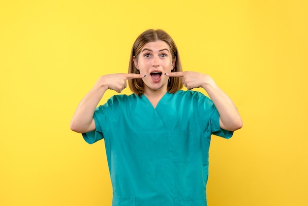 Front view female doctor with excited expression on yellow space