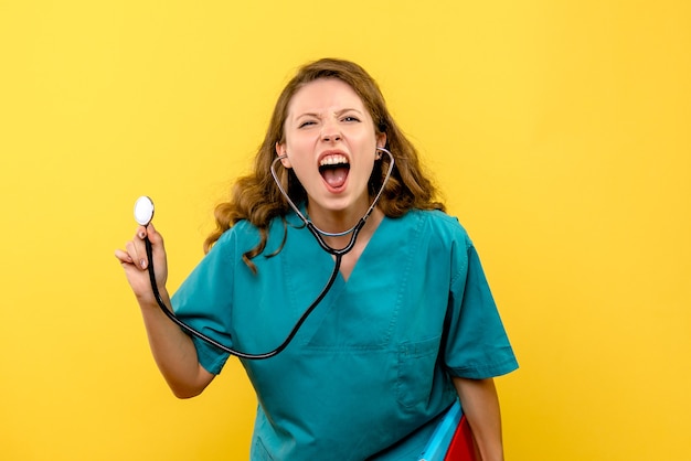 Free photo front view female doctor with files and stethoscope on a yellow space